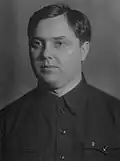 A man in a shirt with dark, curly hair