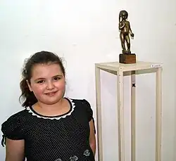 دختر نونه، اوسانا، ایستاده در مجسمه وی