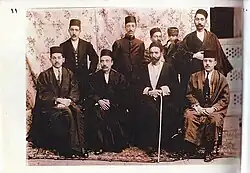 ایستاده از راست: مرتضی خالدی-جمشید خان معدلی بغل سید حسن نوکر-میرزا حبیب‌الله خان معدلی-حسین خان معدلی. نشسته از راست: حسن (آزاد) معدلی-میرزا زین العابدین اعتبارالملک-عبدالله خان اسعدالدوله-لطفعلی خان معدل السلطنه