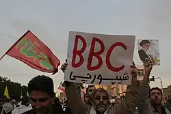 عکس از یک منتقد رسانه بیبیسی در سال ۱۳۸۸ با یک پلاکارد که بر روی آن نوشتهاست: "بیبیسی شیپورچی"، شهر قم