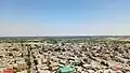 نمای روستای بیدگنه از بالای تخت کیکاووس که در آن، مزارع و باغات ملارد (سمت چپ) و شهریار (تهران) (سمت راست) دیده می شوند