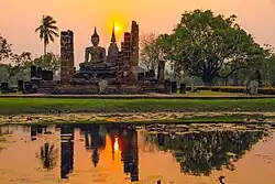 Large white seated Buddha statue, pond in front