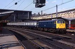 InterCity carriages in British Rail blue-grey livery hauled by a blue Class 85 electric locomotive
