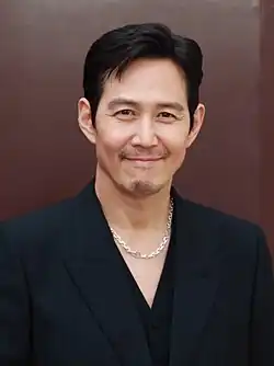 Lee smiling dressed in pink shirt