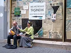 مردی در کنار همسرش در کنار خیابان استقلال، استانبول مشغول به خواندن و نواختن