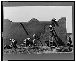 Remudding an adobe wall in Chamisal, circa 1940. Photo: Russell Lee