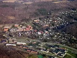 Aerial view of The Village of Alfred, taken April 2006. Visible are three horizontal layers. Central is the Village of Alfred, lower is Alfred State College, and at the upper-middle is Alfred University