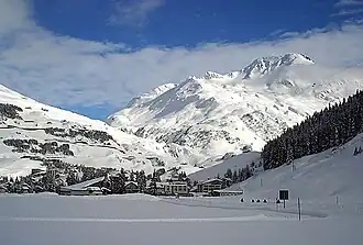 Andermatt looking east towards the Oberalp Pass with cable car (to Gemsstock) bottom station in front and Rossbodenstock (2836m) in the back (۸ فوریه ۲۰۰۳)