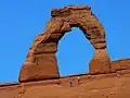 طاق Delicate arch. توجه به اشخاص ایستاده در پایین تصویر (جهت مقیاس) داشته باشید.