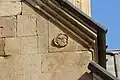 High-relief decoration of a face upon the upper portion of the western façade