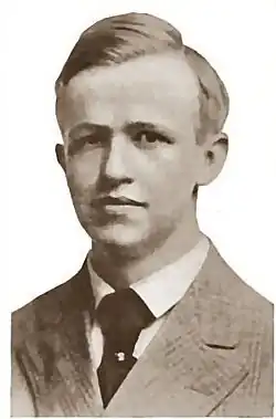 Black and white portrait photo of a white man wearing a hat and coat