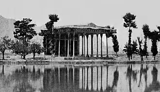 عکسی از کاخ آیینه‌خانه بر ساحل زاینده‌رود مربوط به اواخر دورهٔ قاجار. کوه صفه در پس‌زمینهٔ عکس دیده می‌شود.
