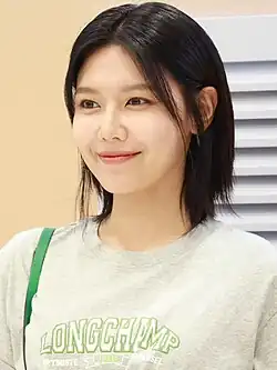 Sooyoung in black office wear and smiling at the camera in 2021