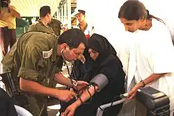 پزشک ارتش در حال معاینه یکی از مسافران