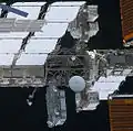 نمای ESP-3 از خدمه STS-133 در حال خروج. ESP-3 دارای آنتن SGANT است، توجه داشته باشید ELC-4 در سمت چپ و ELC-2 در بالا