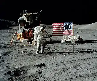 The first image is a successful moon landing in full color containing the American flag, an astronaut, a lunar rover, and a lunar landing module. The second image is an emblem containing a statue of the Greek god Apollo, red stripes inside an eagle made of white lines, the Moon, Saturn, and a spiral galaxy; along the outside of the emblem are is the word "Apollo" along with the number "seventeen" in roman numerals, and then the name "Cernan," "Evans," and "Schmitt." The third and final image contains Schmitt on the left, Cernan in the middle and sitting, and Evans behind Cernan.
