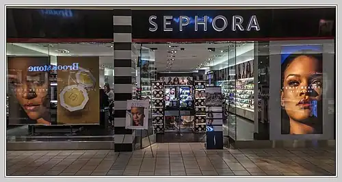 یک ویترین فروشگاه Sephora با پوسترهای بزرگ که دو عکس از نمای نزدیک ریانا و لوازم آرایشی را نشان می‌دهد.