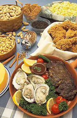 چندین بشقاب پر از غلات، میوه‌ها و سبزیجات مختلف بر روی یک میز.