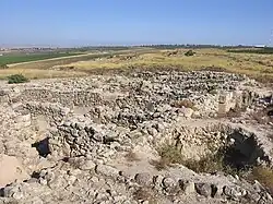 Ruins of buiding consisting of low walls of unhewn stones.