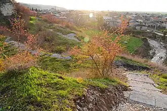 نمایی رو به غرب از دهانه غار هوتو (۱۳۹۲). ساخت منازل مسکونی تا نزدیکی غار ادامه داشته‌است