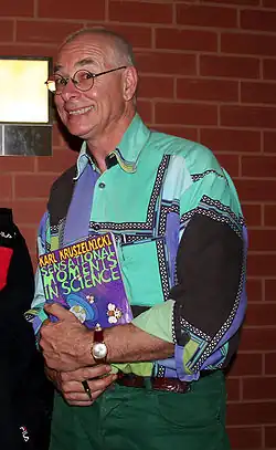 Karl Kruszelnicki holding a copy of his book Sensational Moments in Science