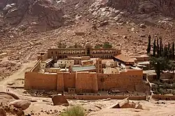 A monastery with high walls in a mountain desert area