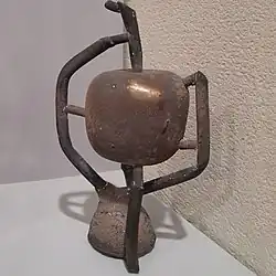 سیب برنزی پس از خروج از قالب؛ قیف ریختگی (به‌صورت وارونه) در پایین مجسمه نمایان است.