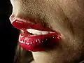 لب های زن جوانی که رژ لب قرمز می پوشد
