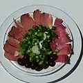 Meat meze with sliced lountza, chiromeri, onions and olives