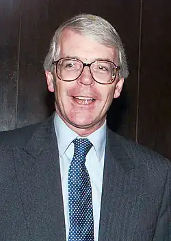 clean-shaven middle-aged white man with grey hair, wearing glasses