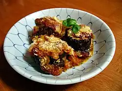 Melanzane alla parmigiana is an Italian oven-baked dish consisting of aubergine, Parmesan cheese, mozzarella and tomato sauce.