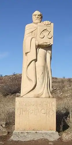 مجسمه مخیتار گُش در ارمنستان که کتاب حقوق در دستش می‌باشد