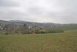 View of Nová ves nad Popelkou of the hill above the cemetery, in the background Mount Tabor
