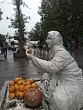 اصطلاح بازارمج در زبان گیلکی به دستفروشان محلی گفته می‌شود. (مجسمه پیاده راه مجموعه میدان، ساختمان و کتابخانه شهرداری رشت)