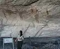 راهنمای گردشگران توضیحاتی راجع به یکی از نقوش ۴۰۰۰ ساله در یکی از غارها می‌دهد.