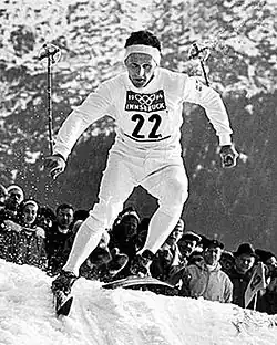 A view of a ski jump hill with crowds surrounding the landing area