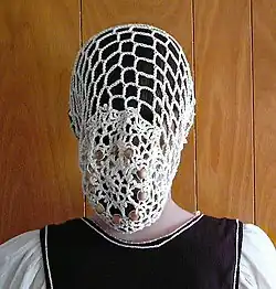 مهره‌های چوبی بافته شده در یک توری قلاب‌بافی