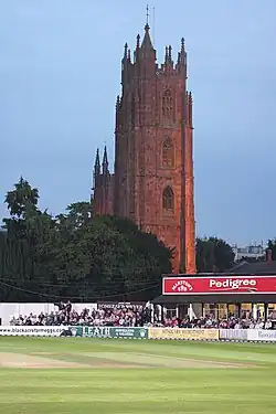 Cricket ground in front of church tower.