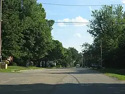 Main part of Tecumseh. Church and Topeka & Shawnee County Public Library bookmobile stop and book drop-off box to the left. خدمات پستی ایالات متحده آمریکا office to the right.