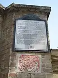لوح نصب شده بر سردر خانهٔ پروفسور عدل که در آن مختصری از تاریخچهٔ ساختمان آمده‌است.