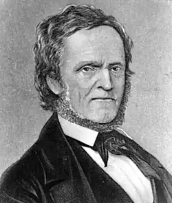 A portrait of William Lyon Mackenzie, depicted sitting in a chair with papers in his hands.