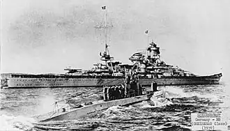 U-47 returns to port after sinking HMS Royal Oak. The battleship Scharnhorst is in the background