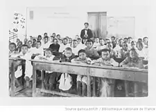 کودکانی که بهتنگی روی نیمکتها و پشت میزها در کلاسی شلوغ نشستهاند
