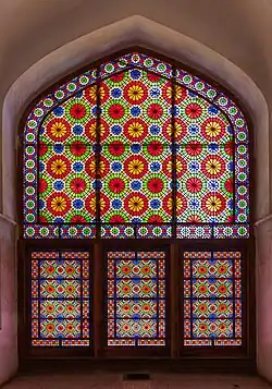 نمایی از داخل عمارت از پنجرهٔ پنجرهٔ اُرُسی مشبک با شیشه‌های رنگی