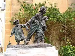 bronze sculpture of three street children running playfully