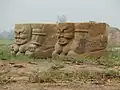 پیکره‌های نگهبان گور با ظاهری شبیه عفریته، تراشیده‌شده بر دو پایه سنگ‌نوشته در آرامگاه شماره ۳ آرامگاه‌های شیای غربی.